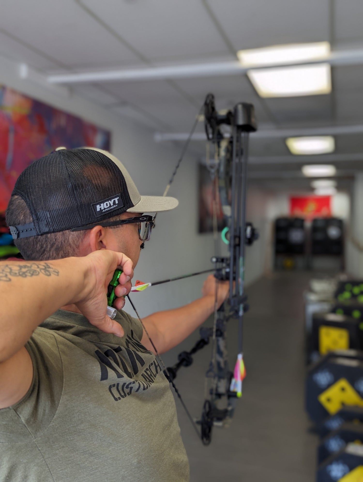 Hunter aiming with black archery rest on bow side view